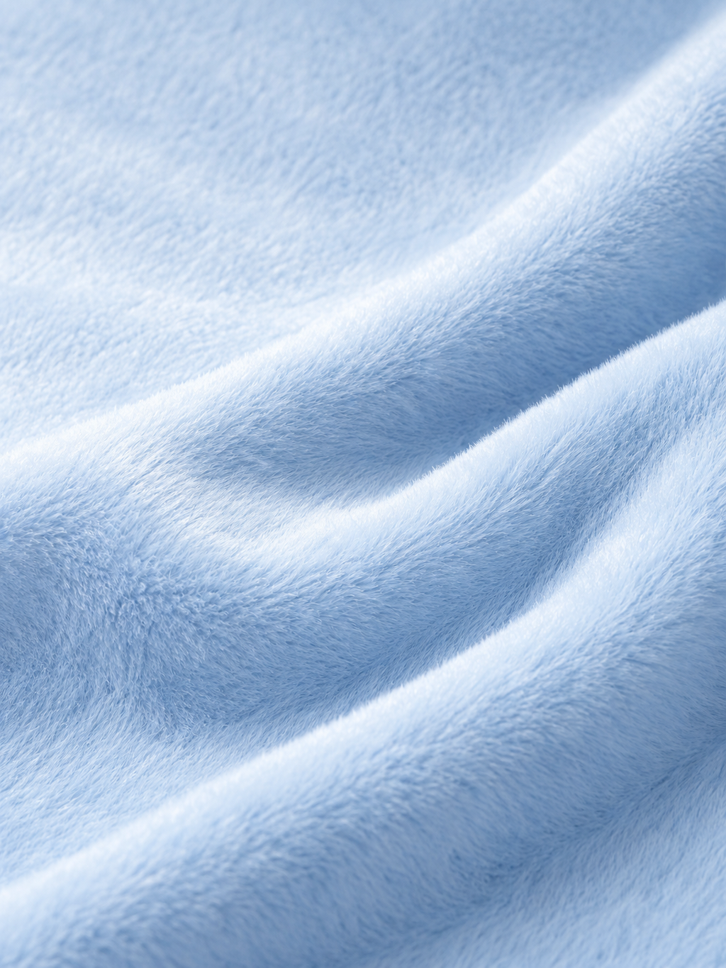 A close-up of soft, light blue plush fabric with gentle folds and a textured, fuzzy surface.