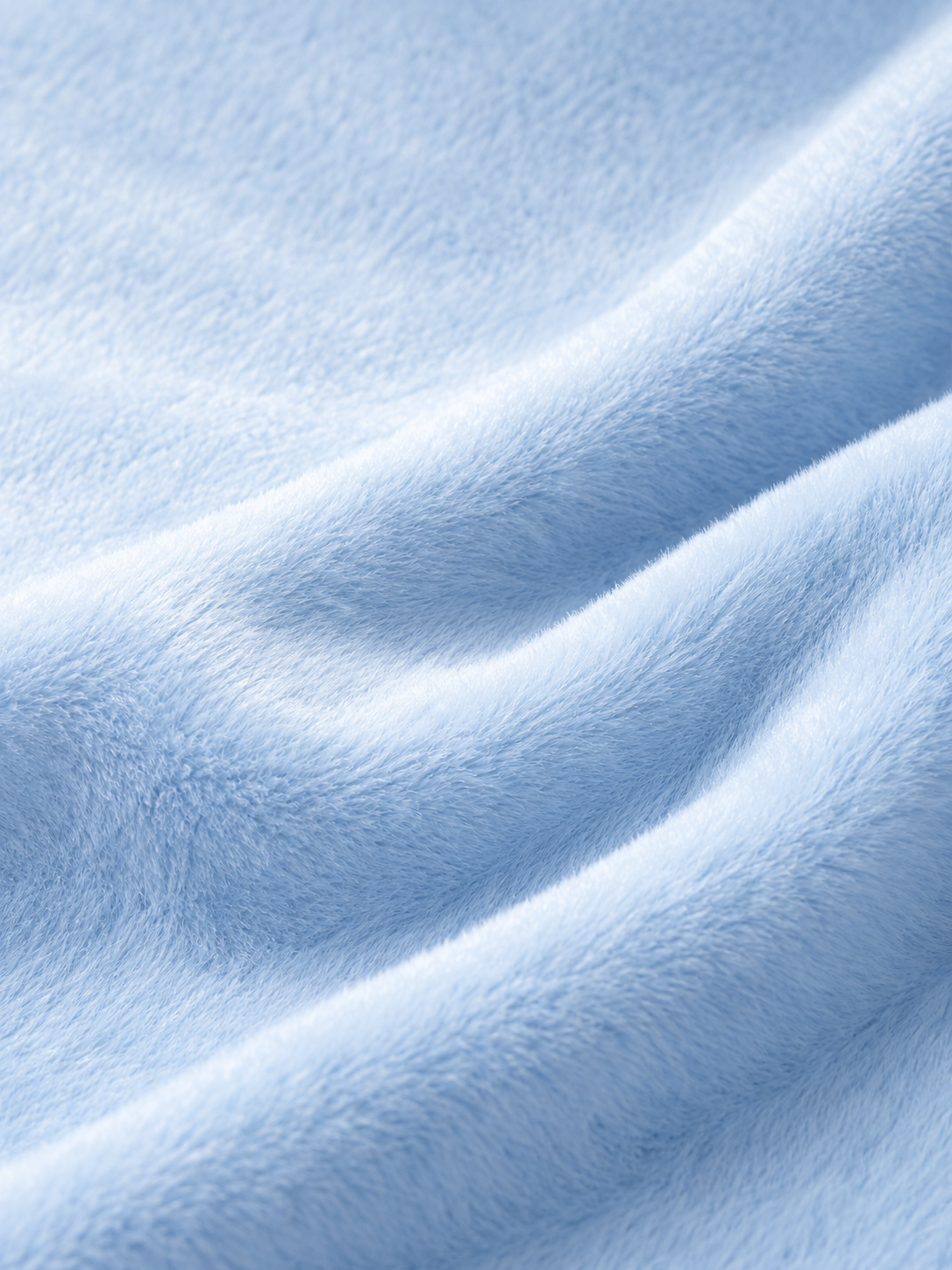 A close-up of soft, light blue plush fabric with gentle folds and a textured, fuzzy surface.